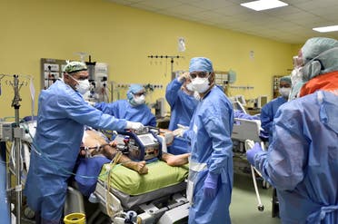 Members of the medical staff in protective suits treat a patient suffering from coronavirus disease in an intensive care unit at the San Raffaele hospital in Milan, Italy. (Reuters)