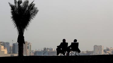 A couple sit on foldable seats along the promenade of the Doha corniche in the Qatari capital on March 16, 2020. (AFP)