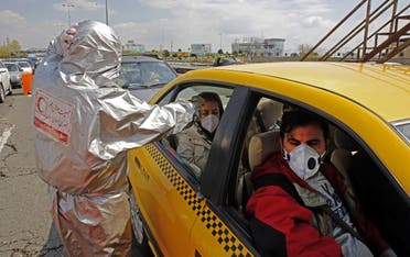 Members of the Iranian Red Crescent test people for coronavirus outside Tehran on March 26, 2020. (AFP)