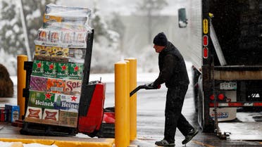 A delivery truck driver guides a large order of beer into a liquor store as shoppers empty the shelves during the closing of bars and restaurants because of the spread of coronavirus on March 19, 2020, in Littleton, Colorado. (AP)
