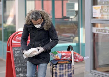 A man wears a face mask as he shops for food at a market in Vienna on March 30, 2020. (AFP)