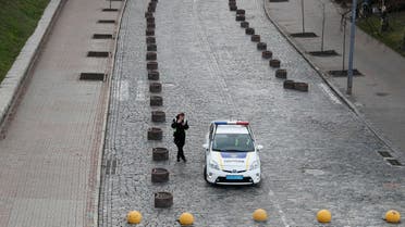 A police officer smokes in an empty street while patrolling central Kiev, Ukraine March 31, 2020. (Reuters)