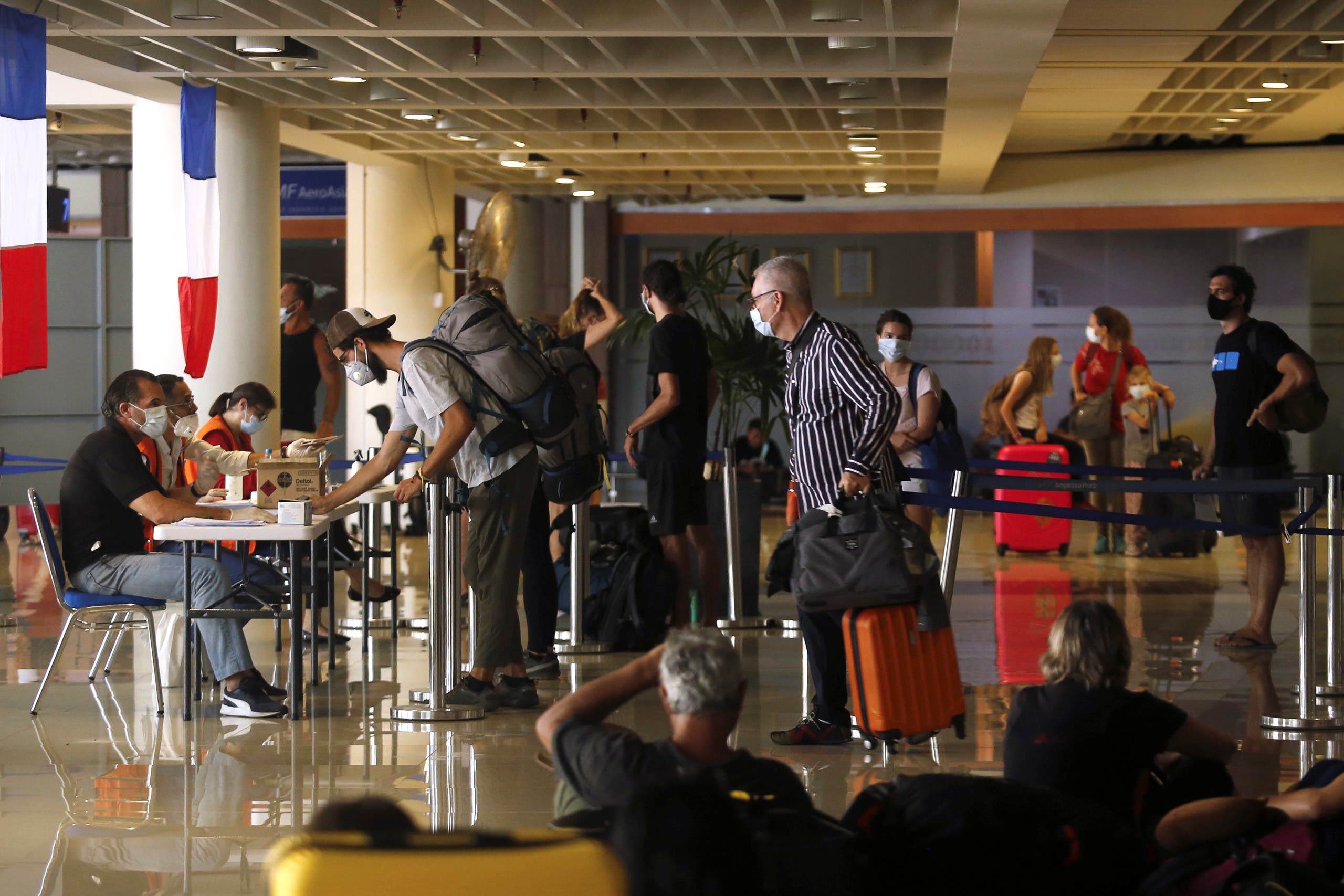 فرنسيون يهرعون للتسجيل عند موظف القنصلية الفرنسية في مطار بالي استعداداً للإجلاء من الجزيرة