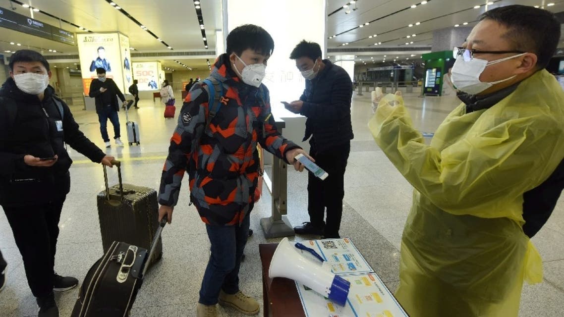 A traveler shows a green QR code that indicates his health status on his mobile phone to a worker at a railway station in Zhejiang province, China, February 17, 2020. (China Daily via Reuters)