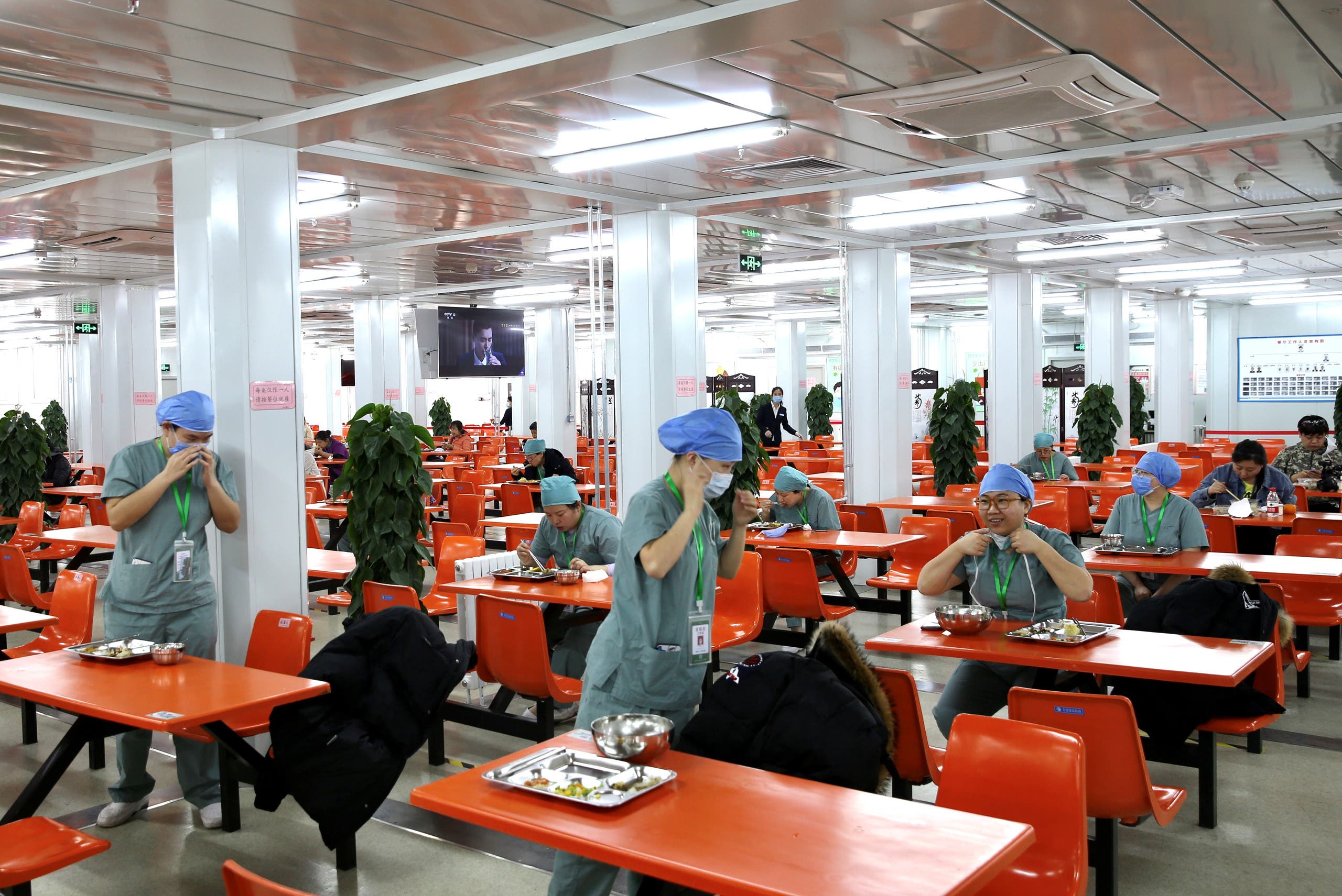 أطباء يتناولون الطعام كل على حدة على طاولات منفردة في أحد مستشفيات بكين
