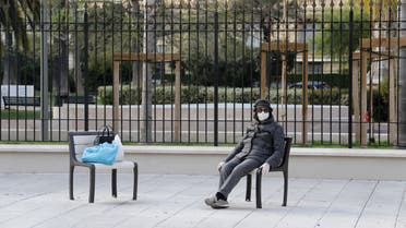 A woman wearing a protective face mask sits in a deserted street in Nice , as a lockdown is imposed to slow the rate of the coronavirus disease (COVID-19) in France, March 28, 2020. REUTERS/Eric Gaillard