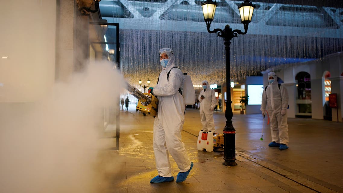 Volunteers in protective suits disinfect a shopping complex in Wuhan, Hubei province, the epicentre of China's coronavirus disease (COVID-19) outbreak, March 31, 2020. REUTERS/Aly Song