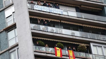 People confined in their homes applaud from their balconies in support of healthcare workers, outside Fundacion Jimenez Diaz hospital, amid the coronavirus disease (COVID-19) outbreak, in Madrid, Spain, March 30, 2020. Banner reads Your dedication makes us believe. REUTERS/Sergio Perez