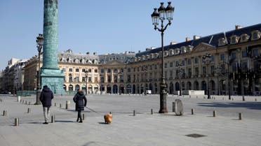 Local residents walk on the deserted Place Vendome in Paris as a lockdown is imposed to slow the rate of the coronavirus disease (COVID-19) in France, March 27, 2020. REUTERS/Charles Platiau