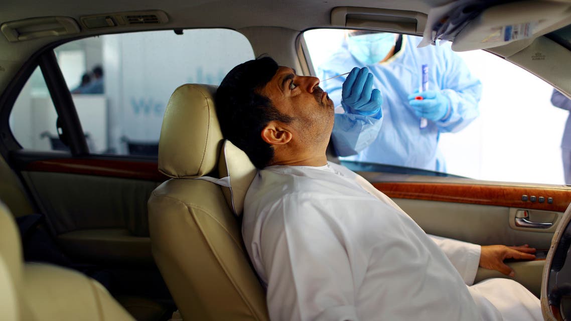 A member of medical staff wearing protective gloves takes a swab from a man during drive-thru coronavirus disease testing (COVID-19) at a screening center in Abu Dhabi, UAE. (Reuters)