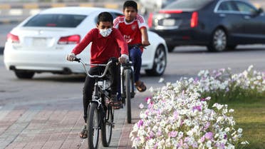 A boy wears a protective face mask, as he rides a bicycle, after Saudi Arabia imposed a temporary lockdown on the province of Qatif, following the spread of coronavirus, in Qatif, Saudi Arabia March 10, 2020. REUTERS/Stringer