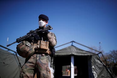 A French soldier, wearing a protective face mask, stands next to tents at a miitary field hospital near Mulhouse hospital as France faces an aggressive progression of the coronavirus disease (COVID-19), March 23, 2020. (Reuters)