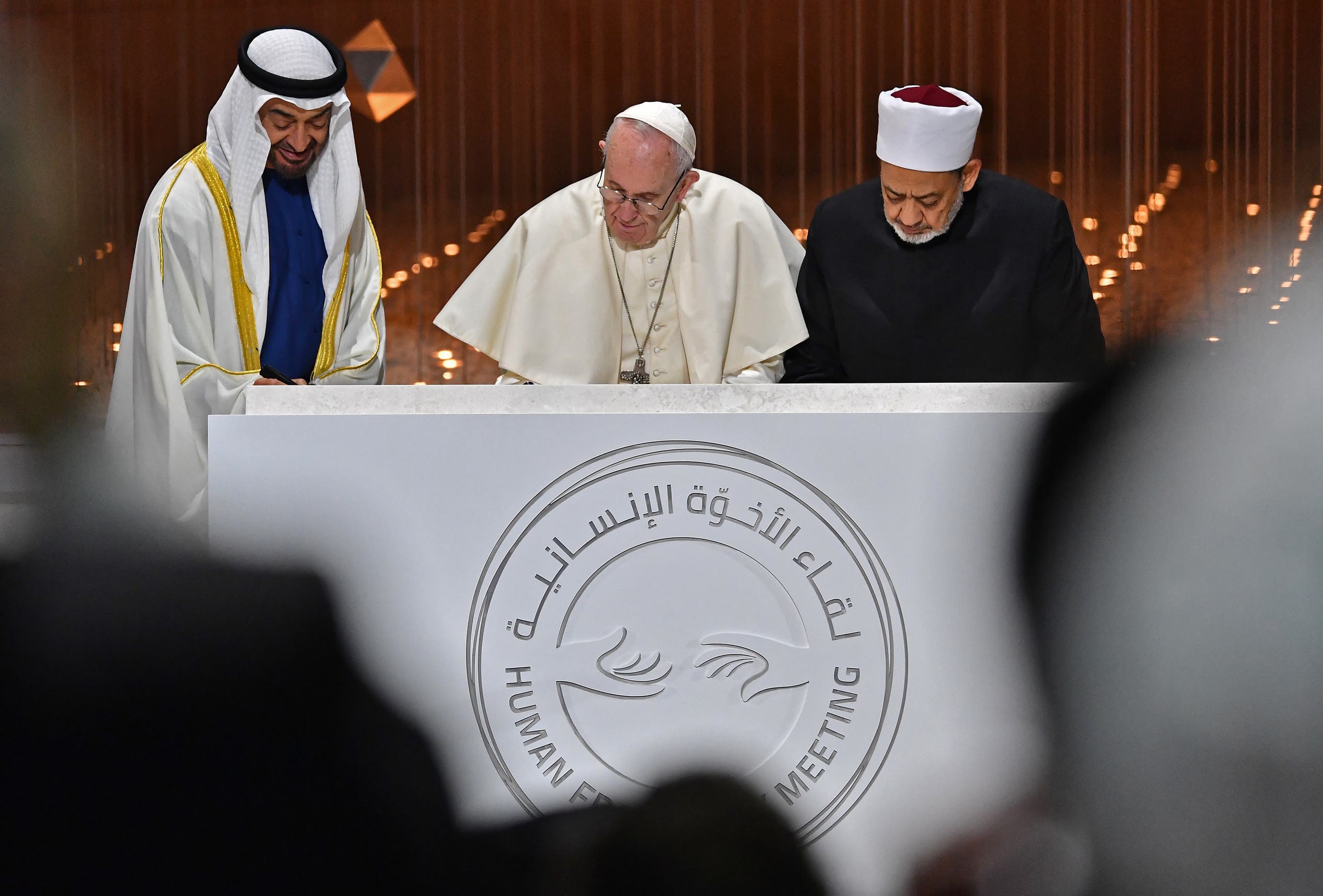 Abu Dhabi's Crown Prince Mohammed bin Zayed Al Nahyan (L) watches as Pope Francis (C) and Egypt's Azhar Grand Imam Sheikh Ahmed al-Tayeb sign documents during the Human Fraternity Meeting in Abu Dhabi on February 4, 2019. (AFP)