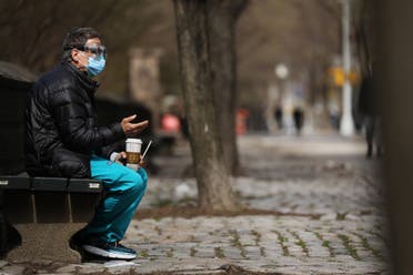 A medical worker takes a break outside of Mount Sinai Hospital amid the coronavirus pandemic on April 01, 2020 in New York City. Hospitals in New York City, the nation's current epicenter of the COVID-19 outbreak, are facing shortages of beds, ventilators and protective equipment for medical staff. (AFP)