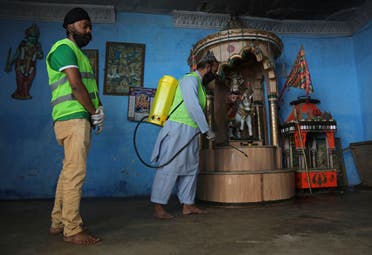A volunteer disinfects the Hindu temple to contain the outbreak of the coronavirus, in Karachi, Pakistan on March 30, 2020. (AP)