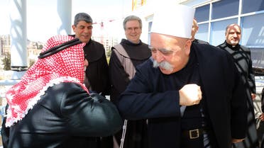 A Muslim and Druze leader bump arms in Jerusalem on March 26, 2020. (Courtesy: GPO)
