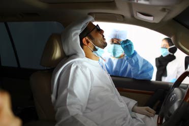 A member of medical staff wearing a protective face mask and gloves takes a swab from a man during drive-thru coronavirus disease testing (COVID-19) at a screening center in Abu Dhabi, United Arab Emirates, March 30, 2020. (Reuters)