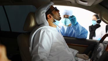 A member of medical staff wearing a protective face mask and gloves takes a swab from a man during drive-thru coronavirus disease testing (COVID-19) at a screening center in Abu Dhabi, United Arab Emirates, March 30, 2020. (Reuters)