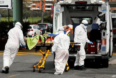 أفراد في الرعاية الصحية ينقلون مريضا بفيروس كورونا في روما يوم 30 مارس من رويترز