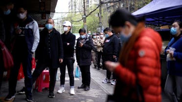 People wearing face masks line up to pay for their breakfast, at a residential area blocked by barriers in Wuhan, Hubei province, the epicentre of China's coronavirus disease (COVID-19) outbreak, April 2, 2020. (Reuters)
