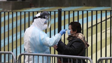 A Hospital worker adjusts as person's mask as he distributes Personal Protective Equipment (PPE) to people waiting in line to be tested for coronavirus disease (COVID-19) in New York City, US, April 2, 2020. (Reuters)