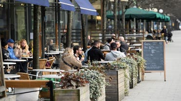 People sit at an outdoor restaurant in Kungstradgarden park amid the new coronavirus (COVID-19) spread, in Stockholm, Sweden March 27, 2020. (Reuters)