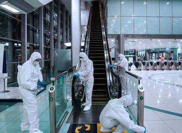 Members of a medical team wearing protective suits clean an escalator, after a curfew was imposed to prevent the spread of the coronavirus disease (COVID-19), in Dubai. (Reuters)