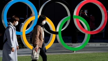 Women wearing protective face masks following an outbreak of the coronavirus disease walk past the Olympic rings in Tokyo. (File photo: Reuters)