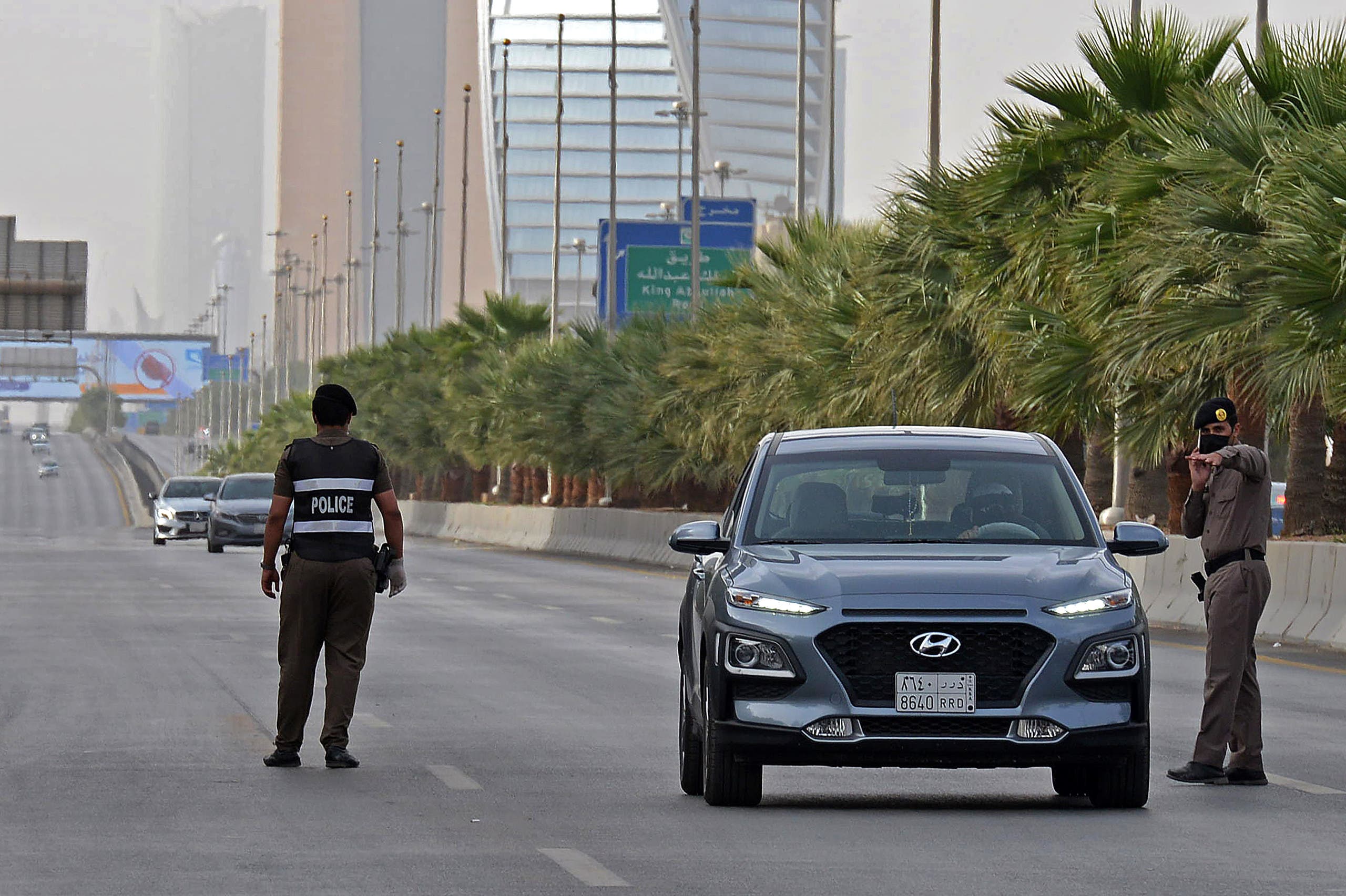 Saudi policemen manning a checkpoint on King Fahd road in the capital Riyadh, after the Kingdom began implementing an 11-hour nationwide curfew. (AFP)