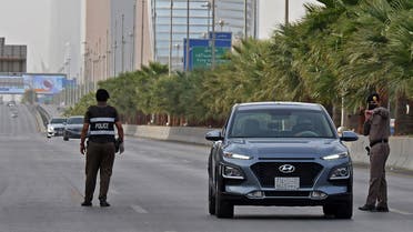 Saudi policemen manning a checkpoint on King Fahd road in the capital Riyadh, after the Kingdom began implementing an 11-hour nationwide curfew. (AFP)