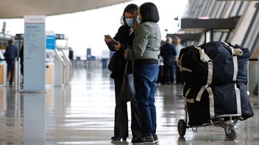 Travelers wear face masks as they prepare to check in for a flight at Dulles International Airport in Dulles, Va., March 17, 2020. (AP)