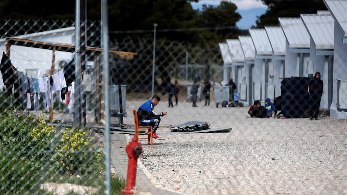 Migrants gather outside their container houses during a quarantine against coronavirus at a refugee camp in Ritsona about 80 kilometers (50 miles) north of Athens. (AP)