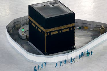 Workers disinfect the ground around the Kaaba, the cubic building at the Grand Mosque, in the Muslim holy city of Mecca, Saudi Arabia, Saturday, March 7, 2020. (AP)
