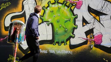 A man passes a graffiti on a wall during the coronavirus disease (COVID-19) outbreak in Vienna, Austria. (Reuters)