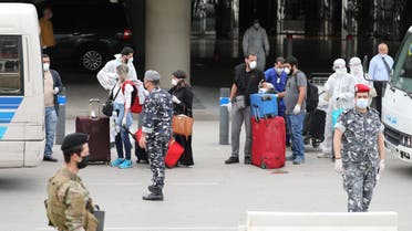Lebanese people, who were stranded abroad by coronavirus lockdowns, are pictured wearing face masks and gloves as they hold their luggage upon arrival at Beirut's international airport, Lebanon April 5, 2020. REUTERS/Mohamed Azakir