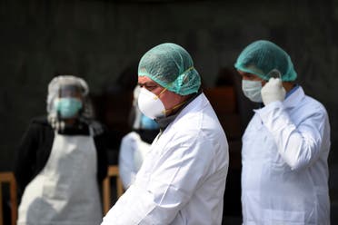Afghan health services staff wearing protective gear, as a preventive measure against the spread of the COVID-19 coronavirus, wait to check the body temperature of guests ahead of the start of Afghanistan President Ashraf Ghani's swearing-in inauguration ceremony, at the Presidential Palace in Kabul on March 9, 2020.