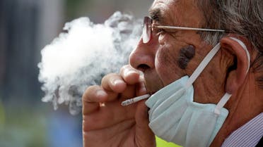 A man wearing a face mask smokes a cigaret, as Albanian authorities take measures to stop the spread of the coronavirus disease (COVID-19) in Tirana, Albania April 6, 2020. REUTERS/Florion Goga