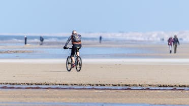 A cyclist rides on a beach amid the coronavirus disease (COVID-19) spread, at Vejers Strand, Jutland, Denmark. (File photo: Reuters)
