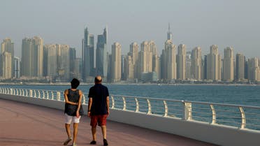 A couple walks at Palm Jumeirah island against the backdrop of Marina Waterfront skyline in Dubai, United Arab Emirates, Saturday, Sept. 22, 2018. (AP Photo)