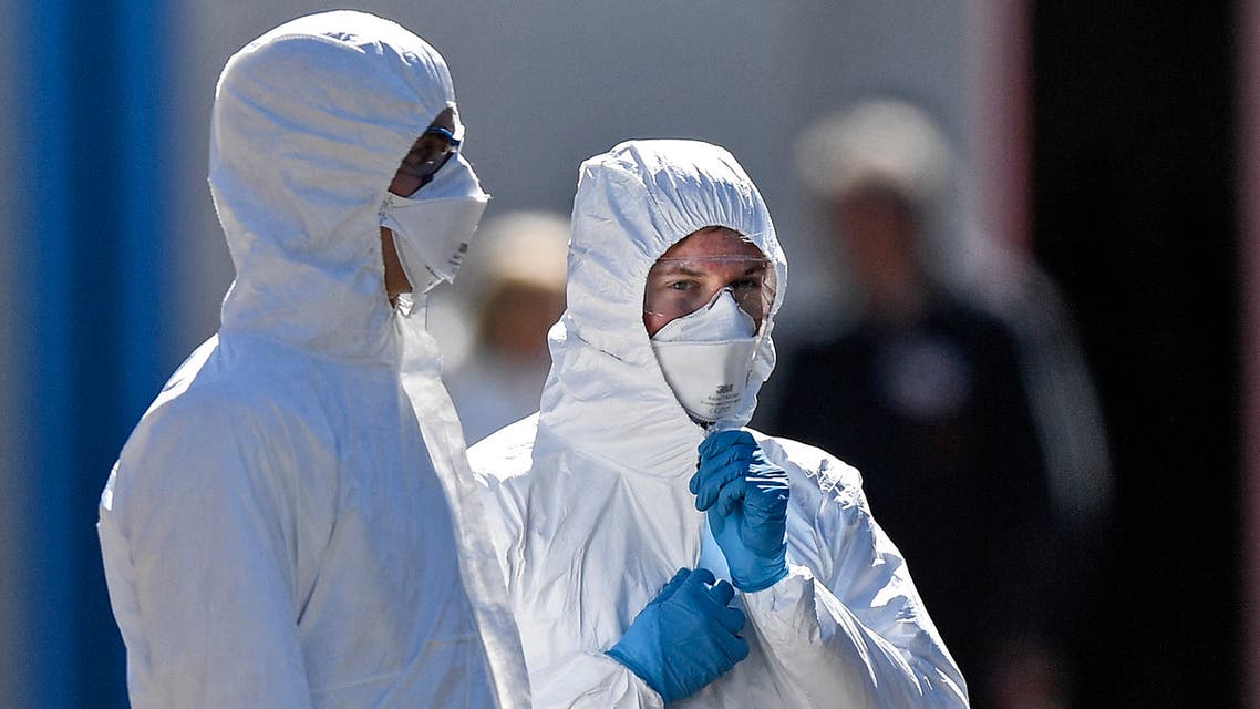 Employees wearing protective clothings wait in the warm sun for the next patient at a coronavirus test station outside the hospital 'Klinikum Nord' in Dortmund, Germany on April 4, 2020. (AP)
