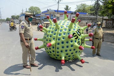 Police officers patrol as inventor Sudhakar Yadav (inside) leads his coronavirus-themed made car on a road for an awareness campaign in Hyderabad on April 8, 2020. (AFP)