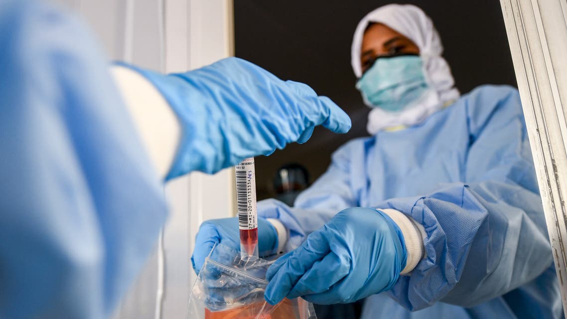 Laboratory workers bag a biological sample at a drive-through COVID-19 coronavirus testing centre in al-Khawaneej district of the gulf emirate of Dubai on April 9, 2020. 
