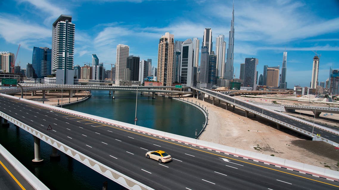 A lone taxi cab drives over a typically gridlocked highway with the Burj Khalifa, the world's tallest building, in the skyline behind it in Dubai, United Arab Emirates on April 6, 2020. (AP)