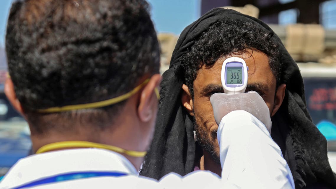 A health official checks the body temperature of man at the entrance of the city of Taez in southwestern Yemen on March 23, 2020 amid concerns over the spread of the COVID-19 novel coronavirus.
