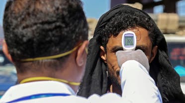 A health official checks the body temperature of man at the entrance of the city of Taez in southwestern Yemen on March 23, 2020 amid concerns over the spread of the COVID-19 novel coronavirus. 