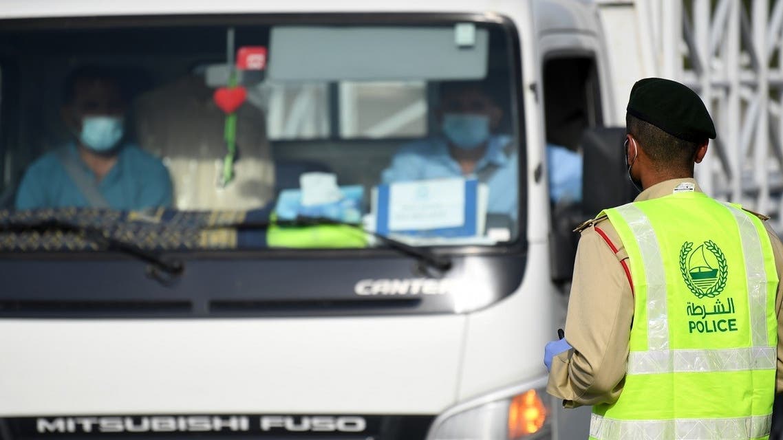 A policeman stops vehicles at a security checkpoint to examine passengers for exit permits, as people are only allowed essential travel due to a lockdown imposed by the UAE government as a measure during the COVID-19 coronavirus pandemic. (File photo: AFP)