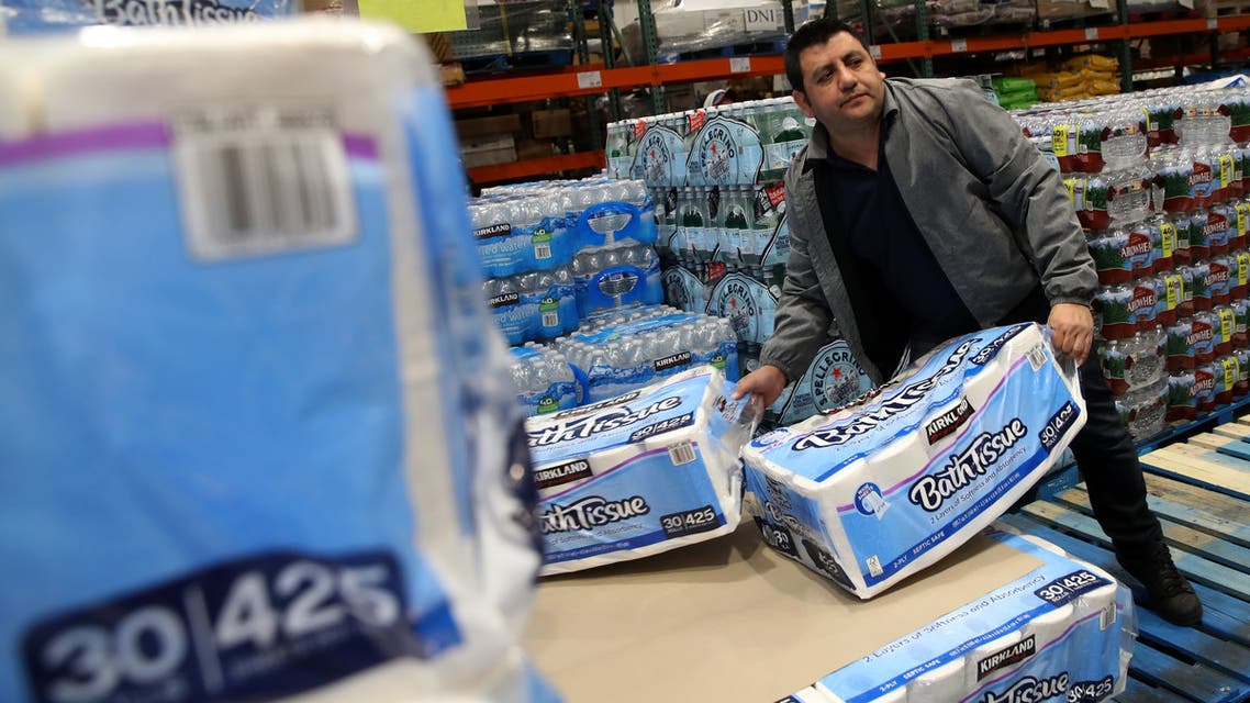 NOVATO, CALIFORNIA - MARCH 14: A customer picks up packages of toilet paper at a Costco store on March 14, 2020 in Novato, California. Some Americans are stocking up on food, toilet paper, water and other items after the World Health Organization (WHO) declared Coronavirus (COVID-19) a pandemic. Justin Sullivan/Getty Images/AFP