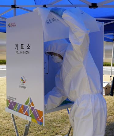 An election officer in protective gear disinfects a polling booth before South Korean patients affected with the coronavirus disease (COVID-19) arrive to cast their ballots for the parliamentary election at a polling station set up at a quarantine center in Yongin, South Korea, April 11, 2020. 