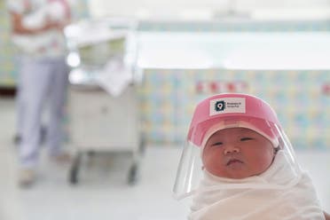 A newborn baby is seen wearing a protective face shield at the Praram 9 hospital in Bangkok. (Reuters)