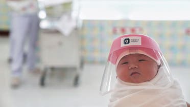 A newborn baby is seen wearing a protective face shield at the Praram 9 hospital in Bangkok. (Reuters)